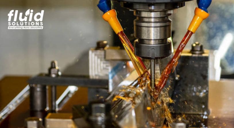 CNC machine with dual coolant nozzles spraying during cutting.