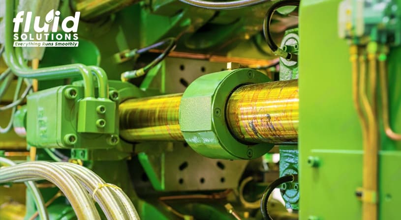 Close-up of a green industrial machine with lubricated components.