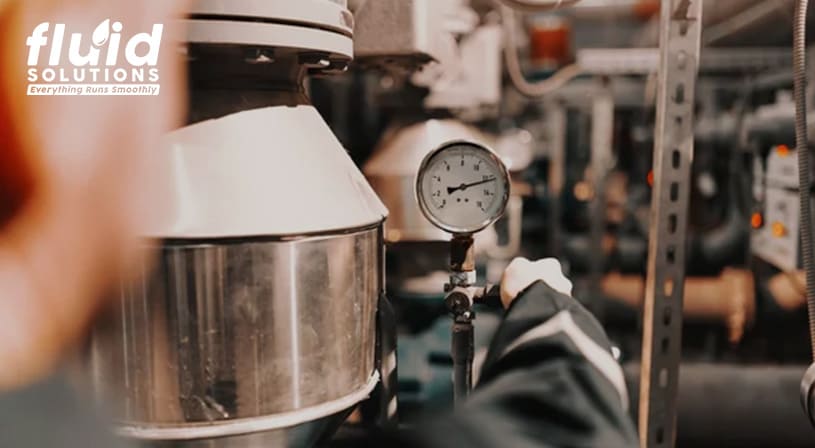 Engineer adjusting a pressure gauge in an industrial setting