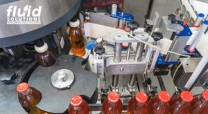 Bottling line machinery filling and capping beverage bottles.