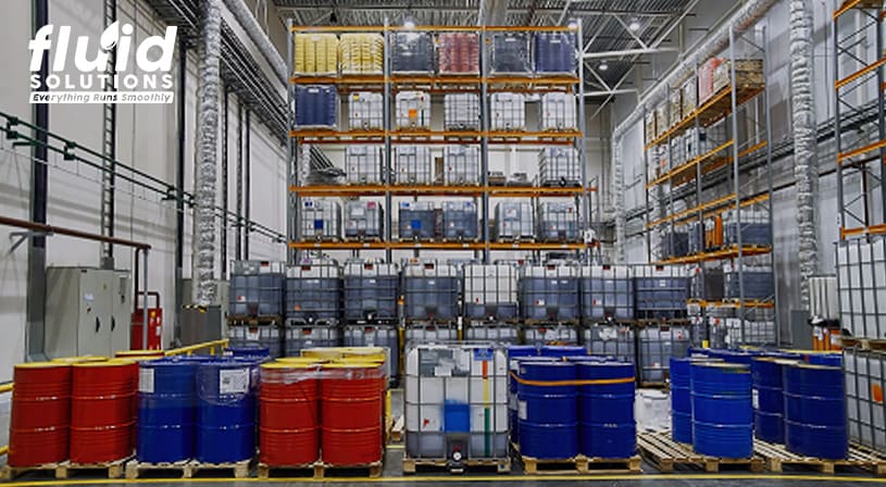 Large storage warehouse with stacked chemical barrels and containers