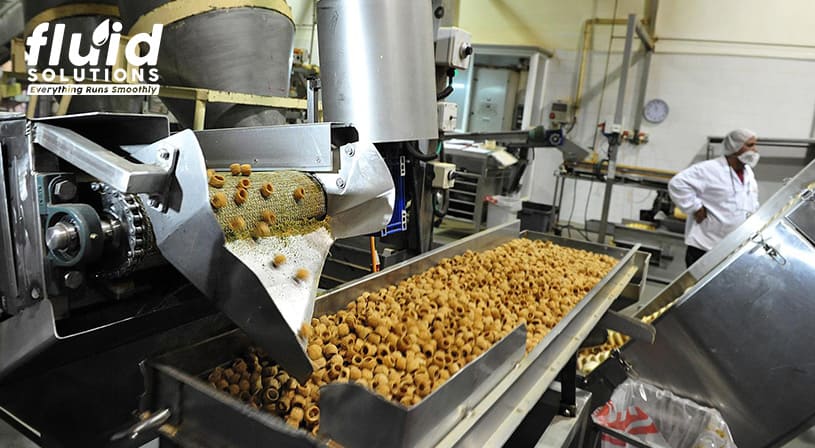 Industrial conveyor belt processing pasta in a food production plant.