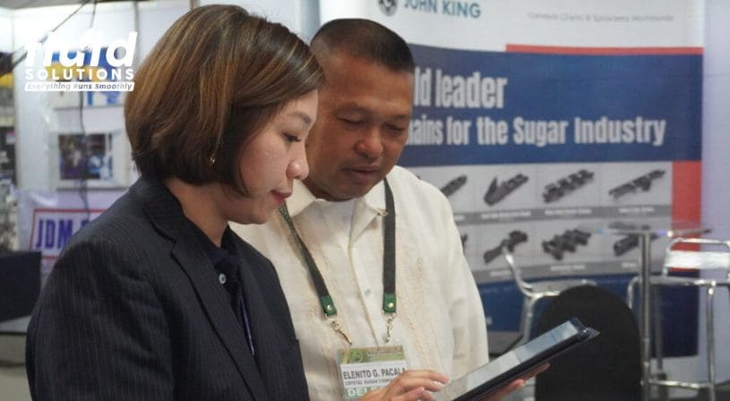 Two people discussing a product at a trade show booth