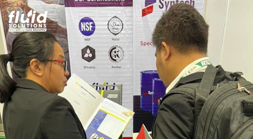 Fluid Solutions representative showing a brochure to a trade show attendee at the booth.