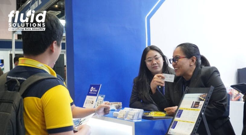 Fluid Solutions representatives talking to a trade show visitor at the booth.