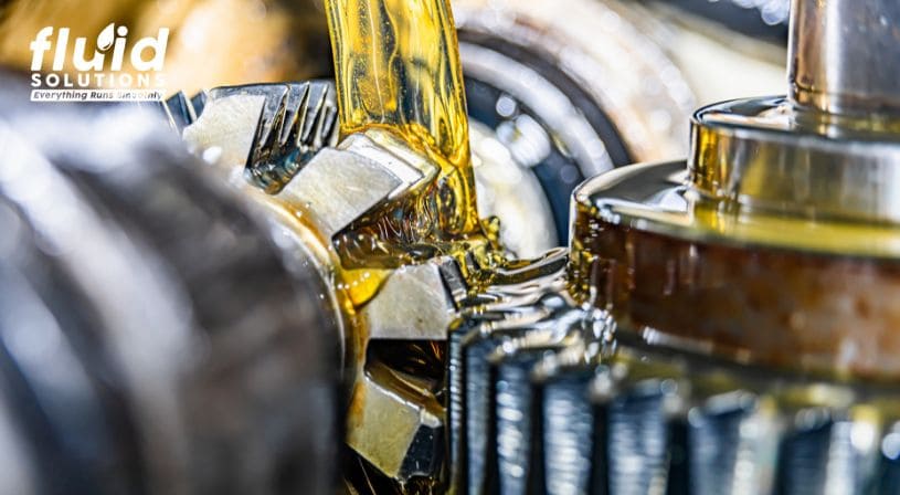 Gear teeth being lubricated with yellow oil.