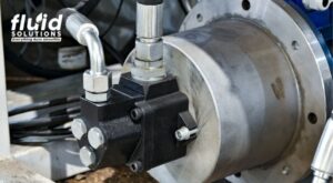 Close-up of a hydraulic pump with connected pipes.