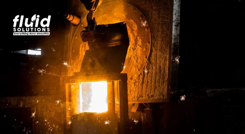 Red-hot metal rods being processed in an industrial machine.