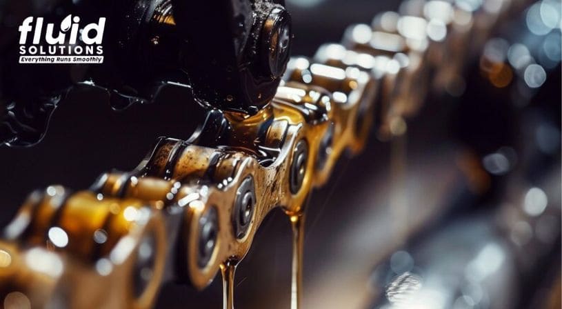 Close-up of oil being applied to a moving chain.