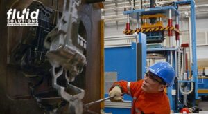 Worker handling a casting machine in an industrial plant