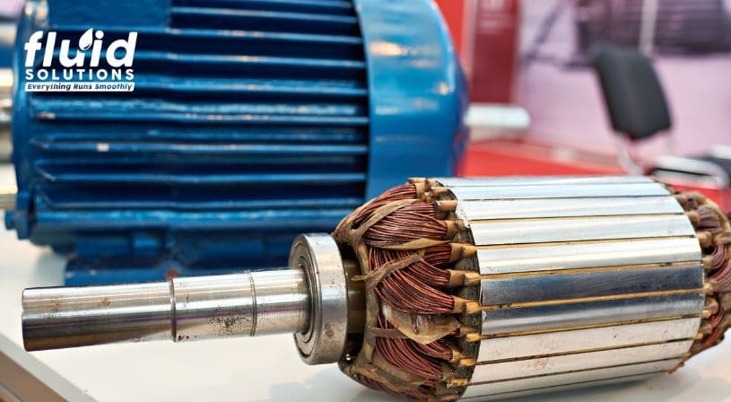 Close-up of an electric motor component and rotor placed in front of a larger motor