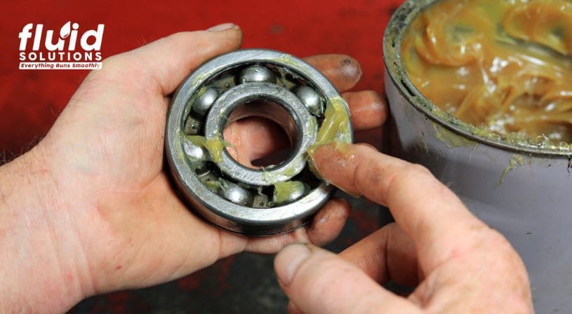 Person applying lubricant grease to a bearing.