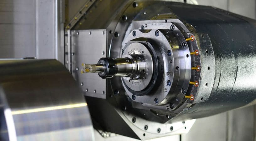 Close-up of a CNC lathe machine spindle with a cutting tool attached.