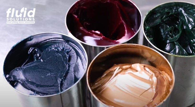 Four open cans of grease in different colors.