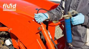 Applying lubricant using grease gun as part of industrial lubrication solutions