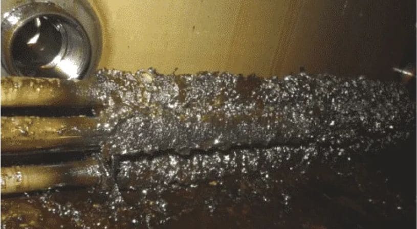 Machinery interior covered in metallic sludge.