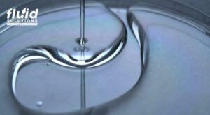 Thick industrial fluid or lubricant pouring smoothly, demonstrating viscosity and flow characteristics