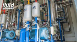 Industrial pump and piping system used for fluid handling and processing in manufacturing facility