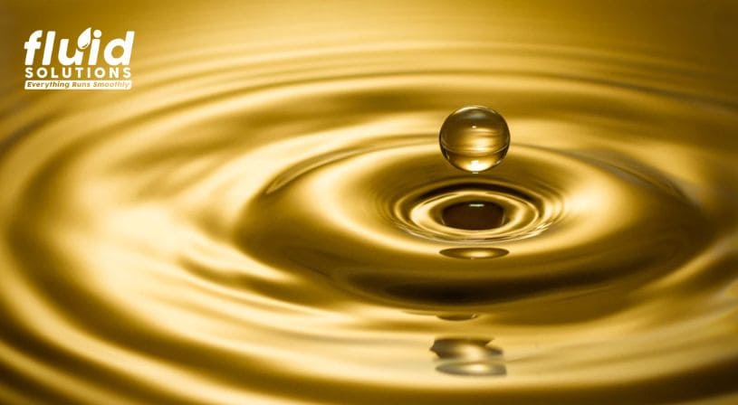 Close-up of a golden oil droplet creating ripples, representing fluid performance and lubrication efficiency