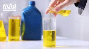 Pouring yellow oil into lab beaker