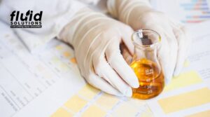Scientist holding a flask with liquid sample during food quality control testing in a laboratory setting