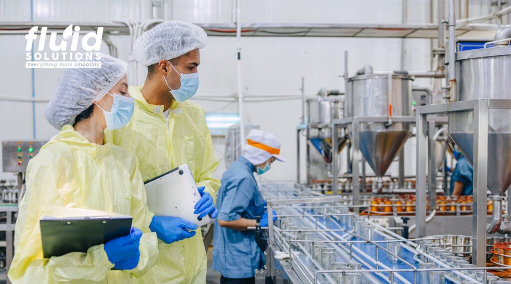 Quality control professionals inspecting a food processing production line using food-safe lubricants and compliance standards.