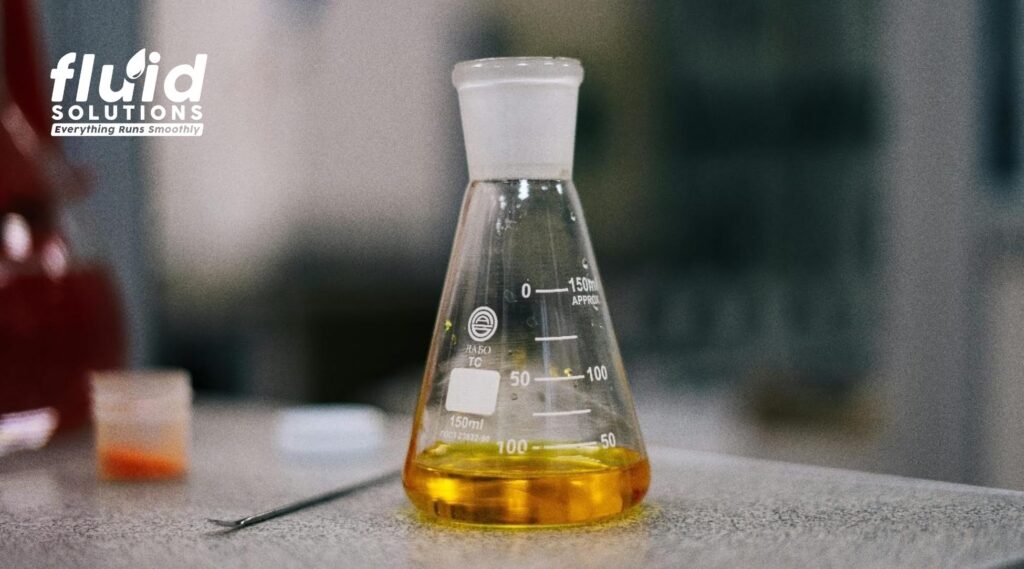 Industrial oil sample in laboratory flask for lubricant analysis, quality testing, and predictive maintenance.
